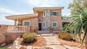 A two-story house with a stone facade, green shutters, and a stone pathway leading to the entrance. - quiet farm to relax 1km from Son Macia (SON MACIA      MANACOR)