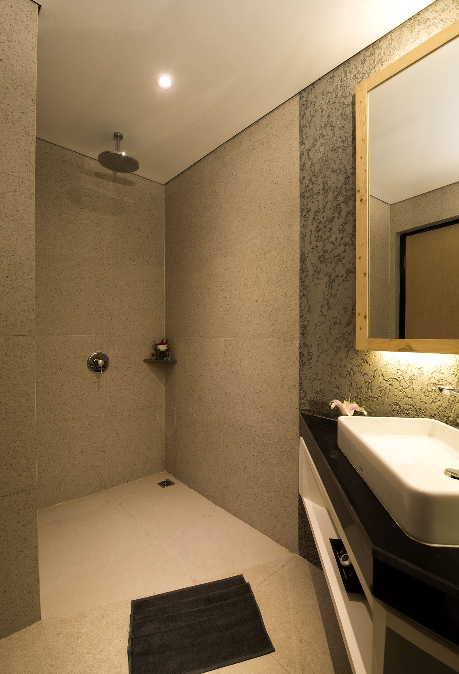 A modern bathroom with a shower, a sink, and a mirror.
