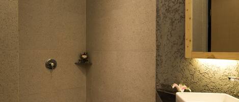 A modern bathroom with a shower, a sink, and a mirror.