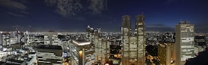 A nighttime cityscape with high-rise buildings, including a prominent twin-tower structure.