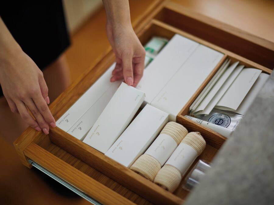 A wooden tray with neatly arranged toiletries including a toothbrush, toothpaste, and a razor.