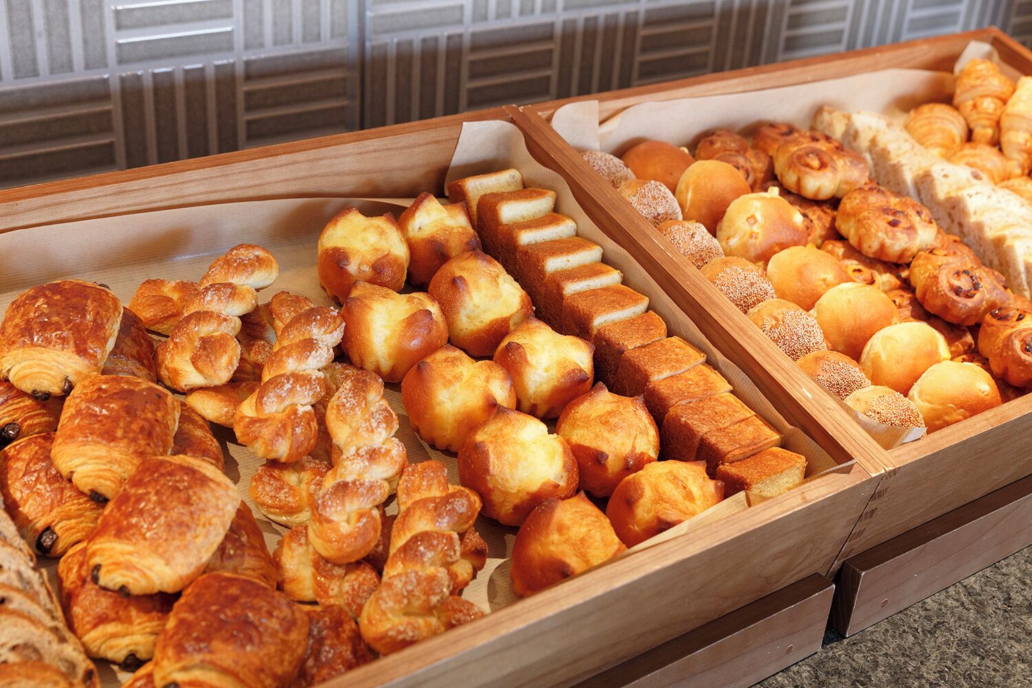 A variety of baked goods displayed in wooden trays.