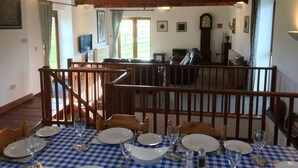 A dining area with a checkered tablecloth, wooden chairs, and a staircase leading to an upper level. - Large Detached "upside Down" Barn, dog friendly with 1 acre enclosed paddock. (wellington)