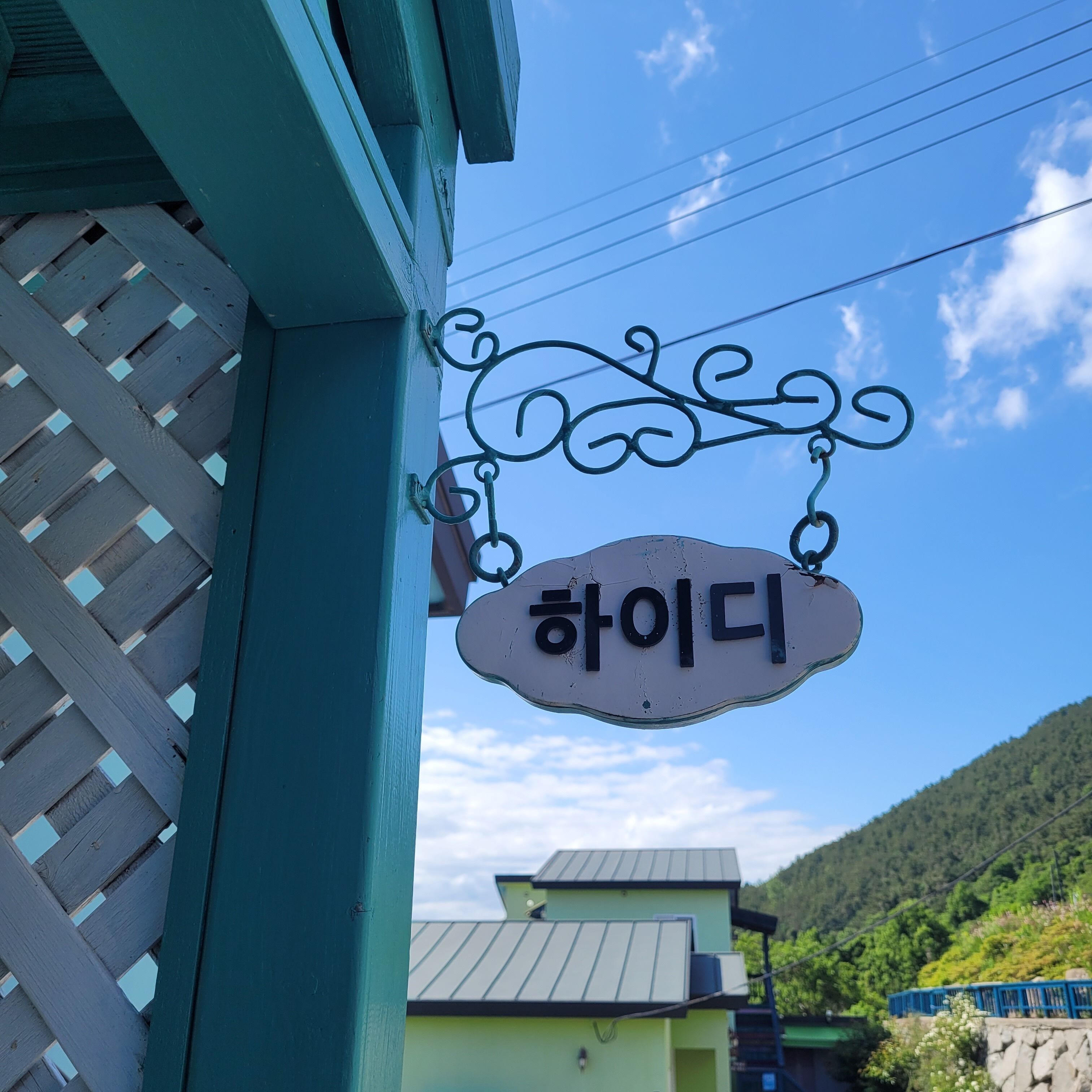 Ein Schild mit koreanischen Schriftzeichen, das an einer Metallkonstruktion hängt.