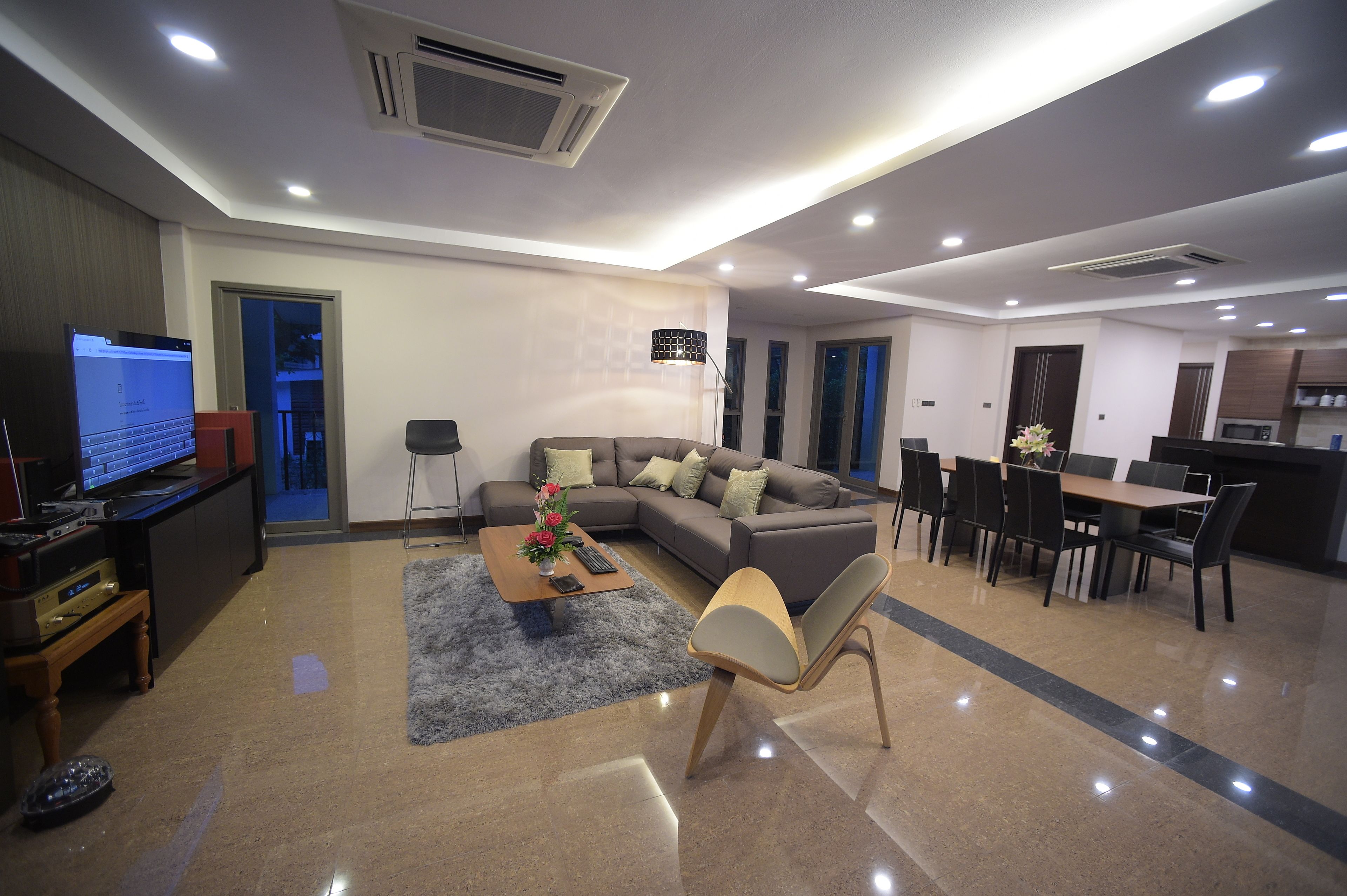 A modern living room with a sofa, coffee table, and dining area.