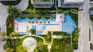 An aerial view of a modern building with a rooftop garden, a swimming pool, and a circular glass structure. - GreenPark Hotel Tianjin (Tianjin)