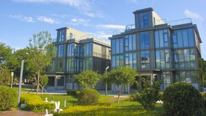 A modern building with large glass windows and a flat roof. - GreenPark Hotel Tianjin (Tianjin)