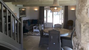 A living room with a sofa, coffee table, and chairs, a chandelier, and a staircase. - Le Mas de Baptiste near the town center with heated, sheltered swimming pool (Saint-Rémy-De-Provence)