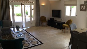 A living room with a sofa, chairs, a TV, and a coffee table. - Le Mas de Baptiste near the town center with heated, sheltered swimming pool (Saint-Rémy-De-Provence)