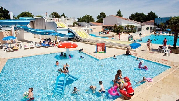 Una piscina con toboganes y zona de parque acuático.