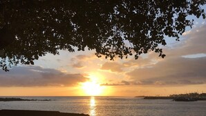 A sunset over a body of water with a wooden structure in the foreground. - Atypical 2 bedroom ground floor apartment with private pool  (saint pierre)
