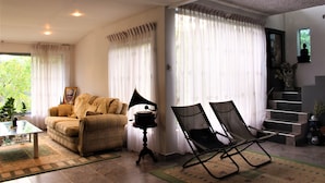 A living room with a sofa, two chairs, a gramophone, and a staircase. - e-stay Hanthana Kandy (Kandy)