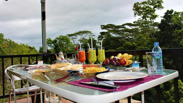 An outdoor dining table with food, drinks, and a water bottle. - e-stay Hanthana Kandy (Kandy)