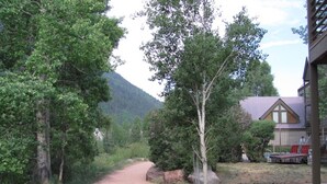 Un chemin de terre mène à un bâtiment doté d’un toit en pente et d’un porche.