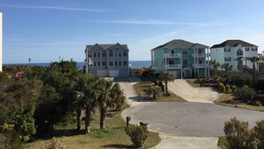 A coastal residential area with two multi-story houses, a paved driveway, and a view of the ocean. - LAST MIN DISCOUNT LABOR DAY! 2nd ROW EASY beach access 1/2 block Ocean View (Emerald Isle)