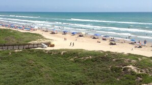 A beach with umbrellas and people. - Beachfront...South Corner 3 Bedroom With Spectacular Views (South Padre Island)