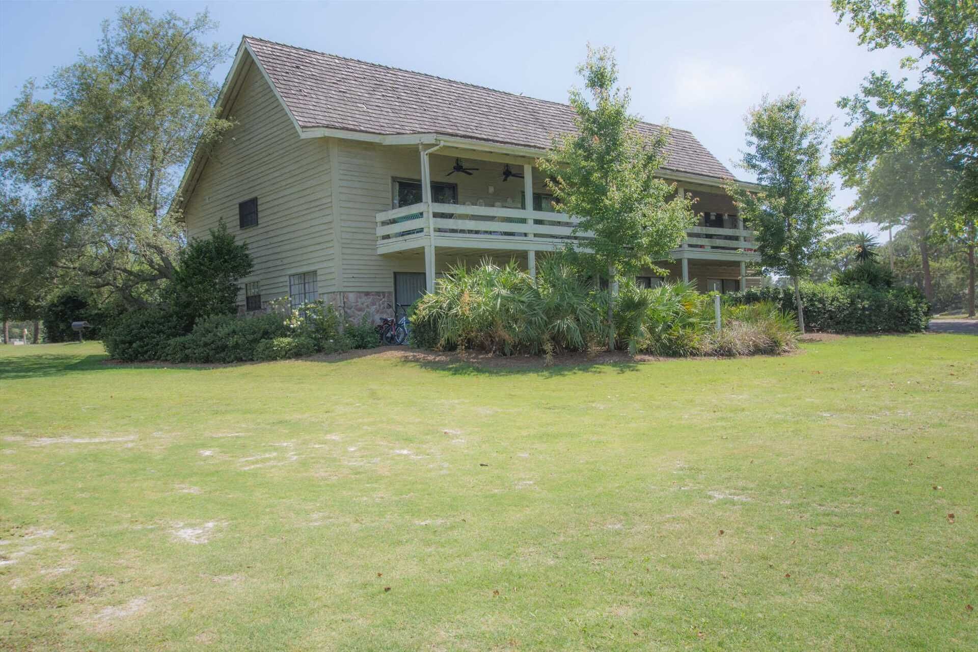 A two-story house with a porch and a lawn in front.