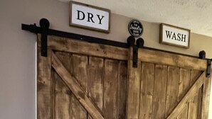 Een houten schuifdeur in boerenerf-stijl, met de aanduidingen 'DRY' en 'WASH' erboven.