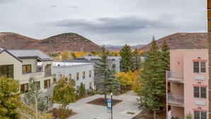 Un quartier résidentiel avec des bâtiments modernes, un ciel dégagé et des arbres aux couleurs automnales.