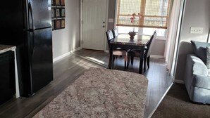 A kitchen with a black refrigerator, a dishwasher, and a dining area with a table and chairs. - Private Upscale Condo in Myrtle w/ Ocean View Across from Boardwalk w/ Huge Deck (Myrtle Beach)