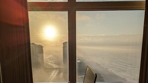 A laptop on a desk with a view of the ocean and buildings through a window. - HUGE Seasonal Discounts & Promotions, Beachfront HUGE End Unit, FREE BeachCHAIRS (Panama City Beach)