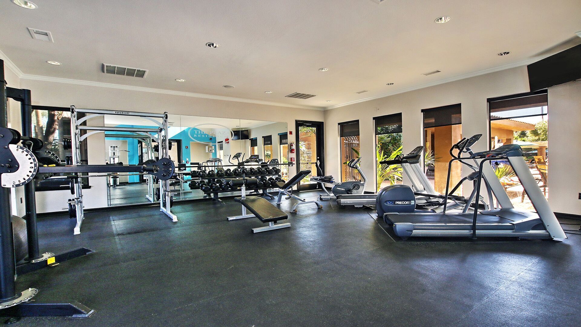 Ett gym med konditionsmaskiner, styrketräningsmaskiner och hantlar.