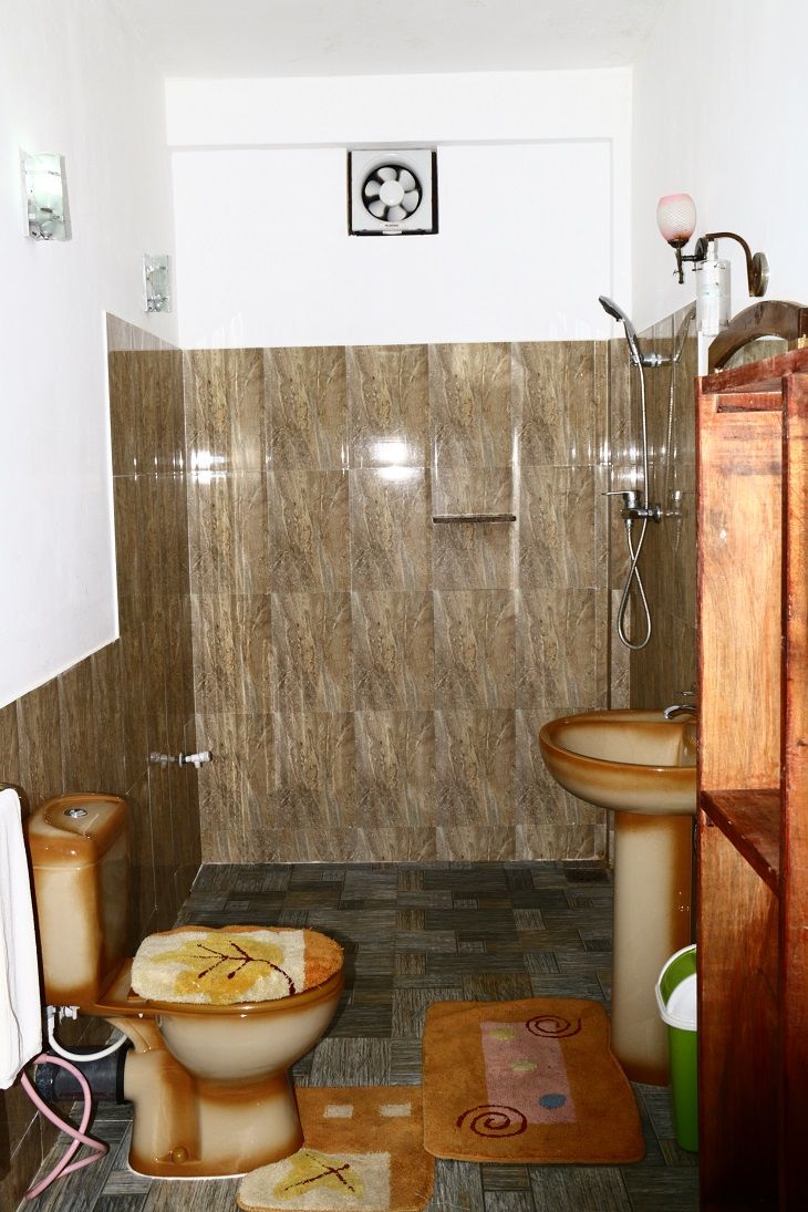 A bathroom with a toilet, bidet, and shower.