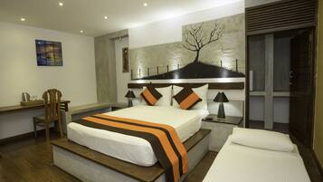 A modern hotel room with a large bed, bedside tables, a desk, and a chair.