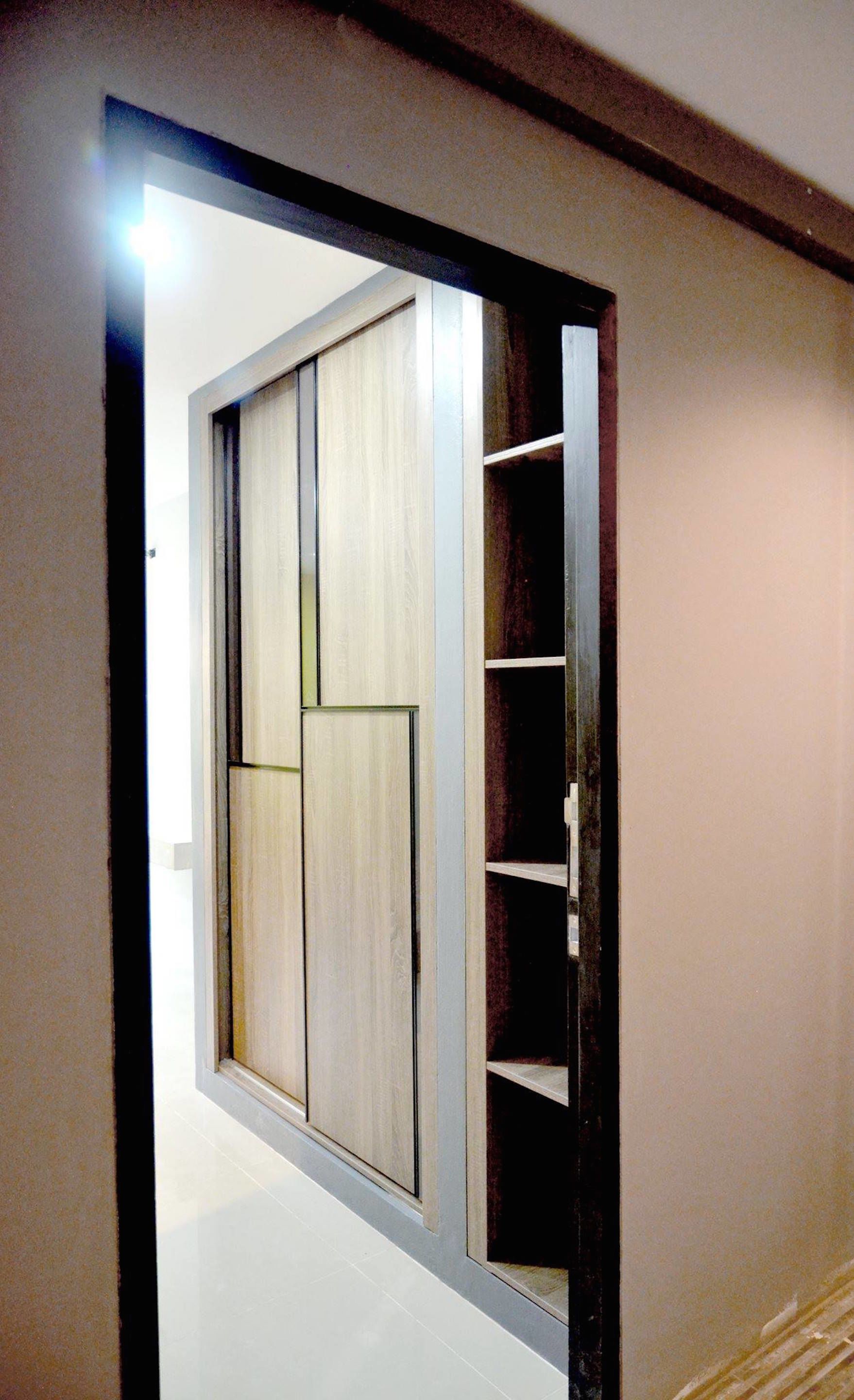 A hallway with a large sliding door leading to a room.