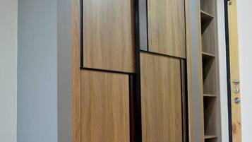 A wardrobe with multiple compartments and a door with a handle.