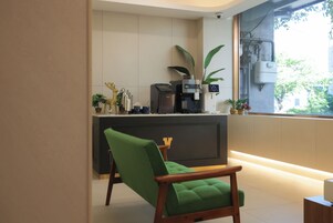 Una cocina moderna con cafetera, un lavamanos y una ventana con vistas a follaje.
