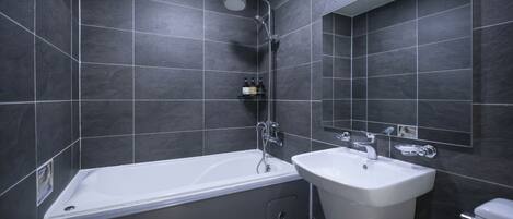 Un baño moderno con bañera, lavamanos y ducha.