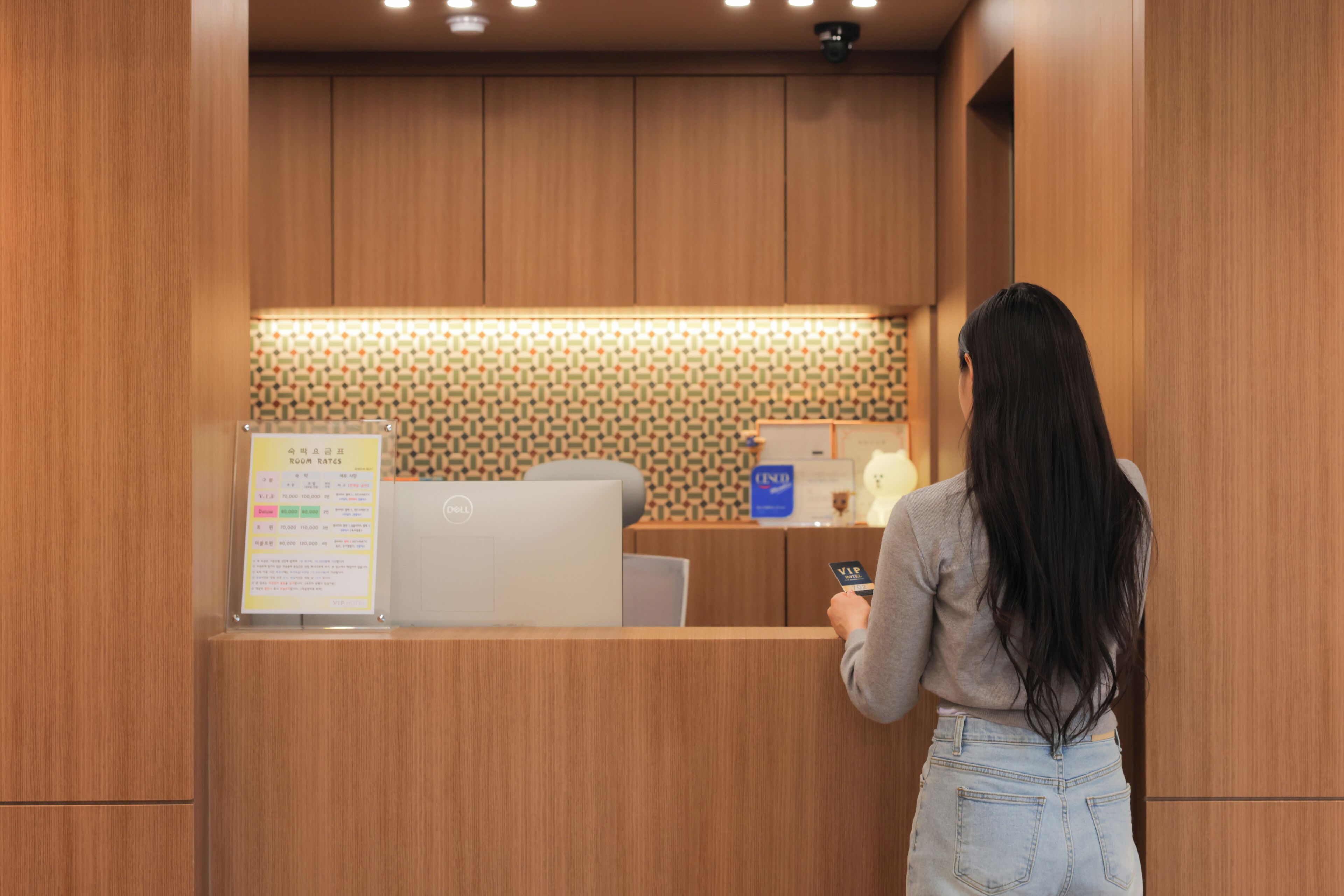 A reception area with a wooden counter, a computer, and a sign with text.