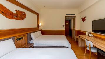 Habitación de hotel con dos camas, un escritorio, una silla, un televisor y una pared decorativa de madera.
