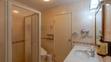 A bathroom with a toilet, sink, and shower.