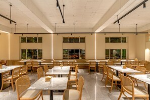 A spacious dining area with multiple tables and chairs, large windows, and a high ceiling. - Ginkgo Hotel (Lugu)