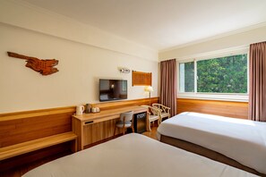 A hotel room with two beds, a desk with a TV, a wooden cabinet, and a window with curtains. - Ginkgo Hotel (Lugu)