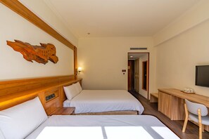 A hotel room with two beds, a desk, a chair, and a television. - Ginkgo Hotel (Lugu)