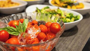 A glass bowl filled with cherry tomatoes and ice cubes.