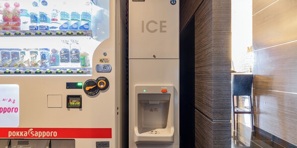 Máquina expendedora con dispensador de agua y botón pulsador.