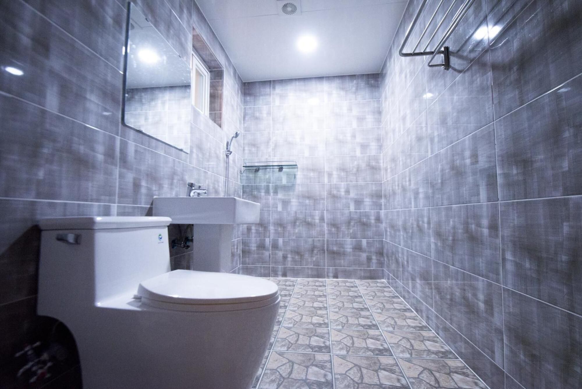A bathroom with a toilet, sink, and shower.