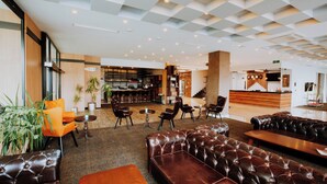 Un hall amplio con sofás de cuero, una barra de café y un mostrador de recepción.