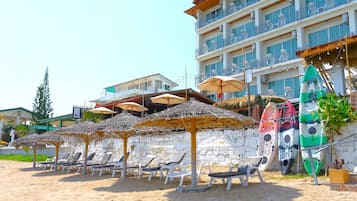 Nyilvános parton, napernyők, strandlepedők és kajakozás