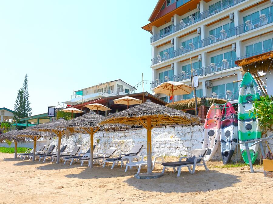 En la playa, sombrillas, toallas de playa, kayak