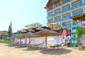 Na praia, guarda-sóis, toalhas de praia, passeios de caiaque