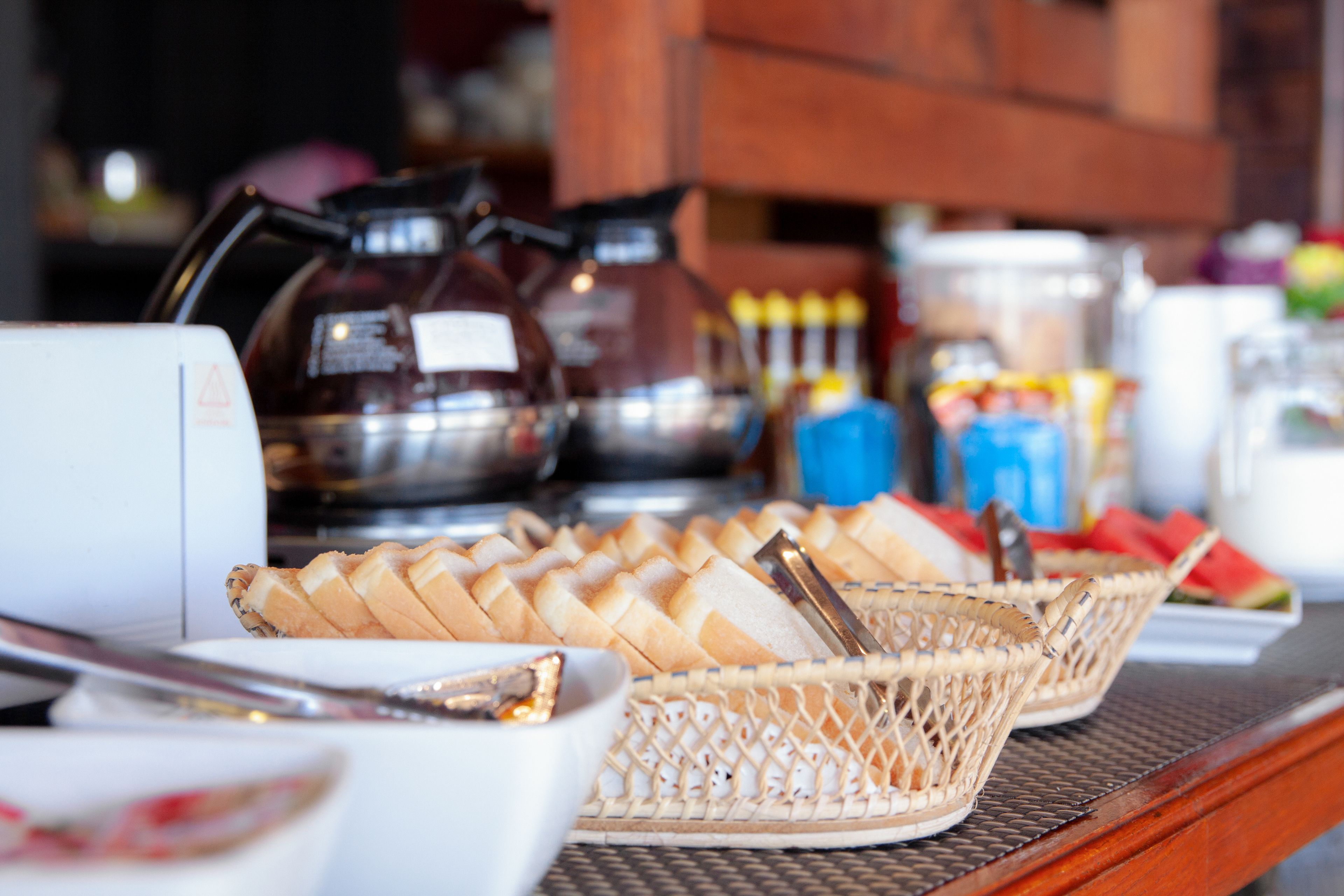 Una mesa de buffet con pan, cestas y salsas.