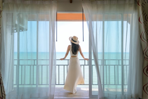 Una habitación con vistas al mar tras cortinas translúcidas.