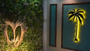 A wall with a vertical garden and a framed silhouette of a palm tree. - Palmiye Suit (Istanbul)