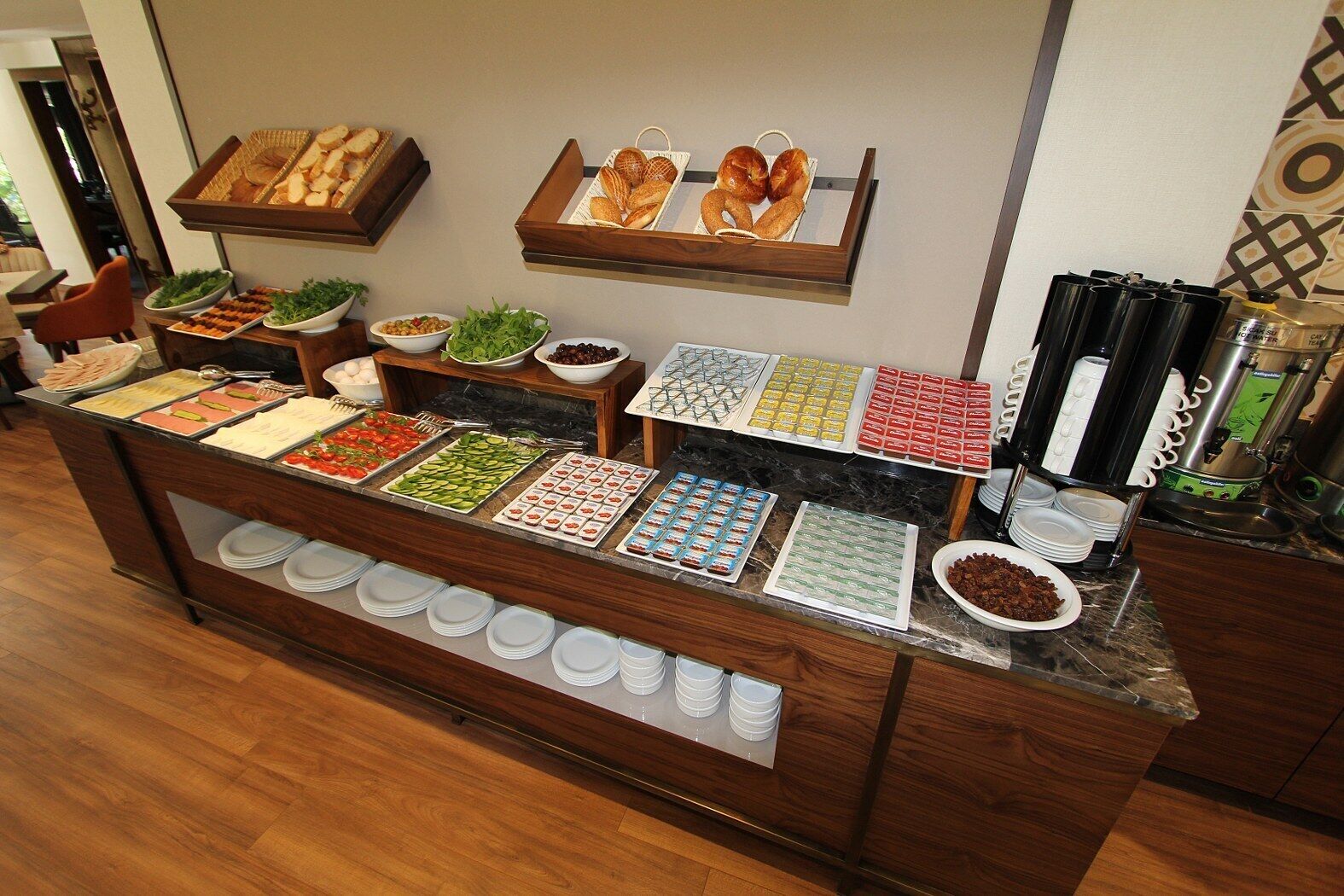 Disposição de buffet com diversos alimentos e uma máquina de café.