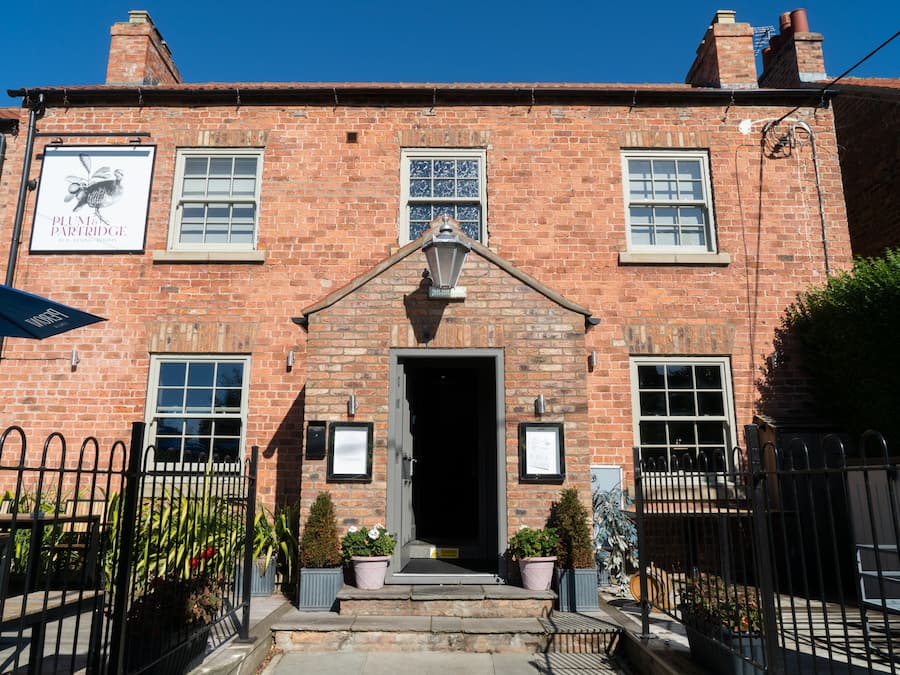 A brick building with a sign reading "Plum Partridge."
